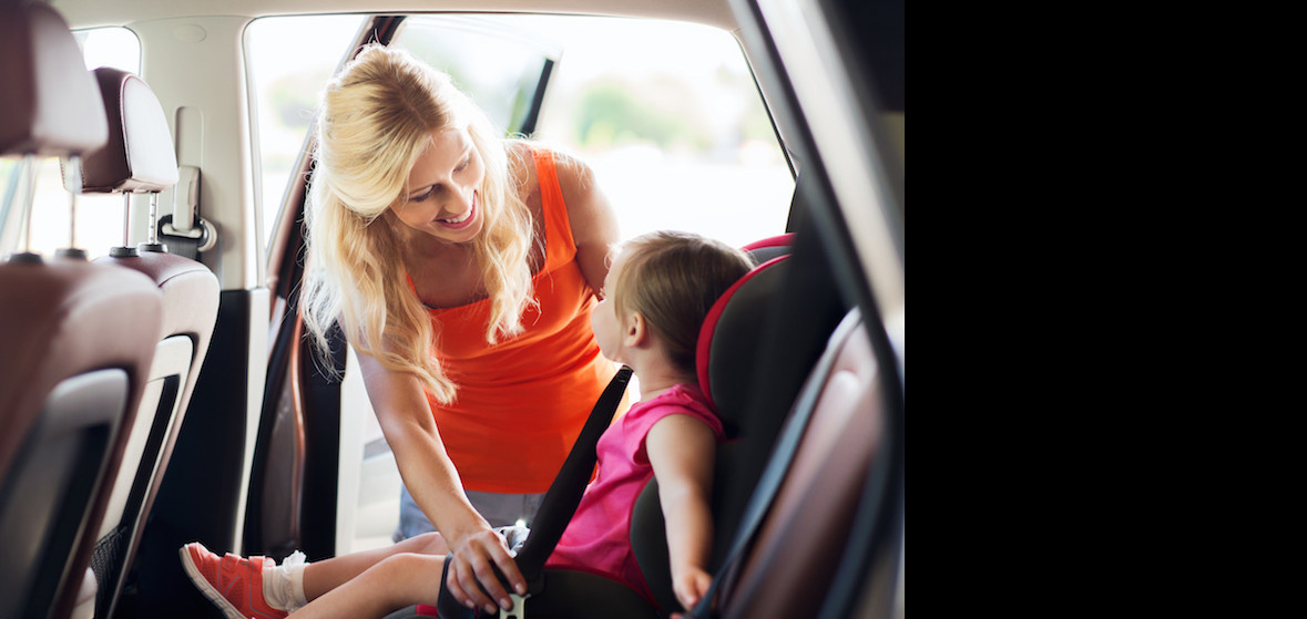 A mom buckling her child into car safely